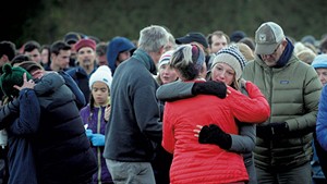 Mourners embracing during a vigil at Harwood Union High School for the teenagers killed in the 2016 crash
