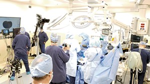 A film crew shooting Dr. Bryan Huber in surgery