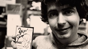 A young Daniel Johnston holding one of his homemade cassettes