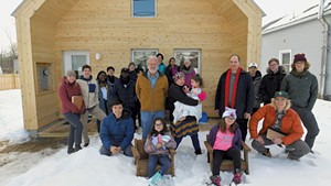 Steve Ingram (center left) and Middlebury College professor John McLeod (center right) with homeowner Dora Rivera (center), her children and McLeod's class