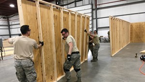 Vermont National Guard members erecting walls inside the exhibition hall