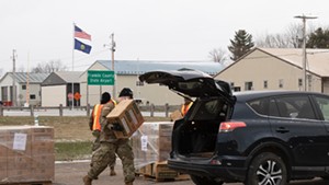 A member of the Vermont National Guard loading a case of MREs into a car in Swanton on April 22