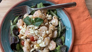 Shrimp with tomatoes and white beans served over greens