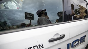 Demonstrators passing a police car in Burlington