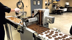 Enrobing machine coating pretzels with chocolate at Vermont Nut Free Chocolates