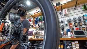 Shop manager Mar Kuhnel &#10;tuning a bike at Ranch Camp