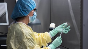 A health care worker prepares a dose of COVID-19 vaccine