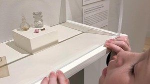 Ruby examines miniature glassware from the museum's global collection