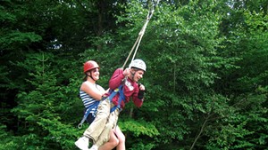 Former Partners in Adventure staff member Sarah and camper Chris swing together at Bolton Adventure Center