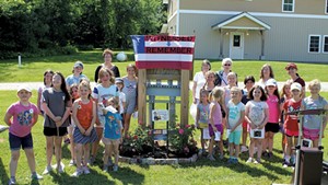 Girls at Camp Farnsworth flank the new Rosie the Riveter garden