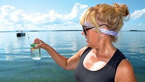 Cathy Hickory with a sample of lake water