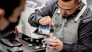 A competitor in the U.S. Coffee Championships 2022 Latte Art Championship in Boston