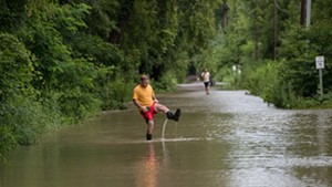 A man walking through flood waters at Burlington's Intervale on Tuesday