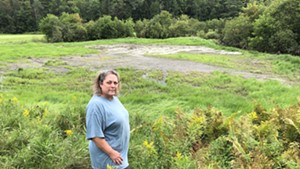 Margo Killoran, a horse breeder in Marshfield, standing in her flooded hayfield