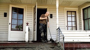 Gordon George cleaning his front porch