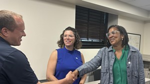 Jessica Brown shaking hands with Police Chief Jon Murad as Mayor Emma Mulvaney-Stanak looks on