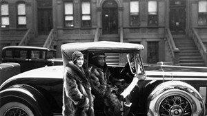 "A Harlem Couple Wearing Raccoon Coats Standing Next to a Cadillac on West 127th Street," photograph by James Van Der Zee