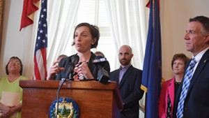 Nicole Mace, executive director of the Vermont School Boards Association, talks about potential savings in teacher health care costs, with Gov. Phil Scott last month.