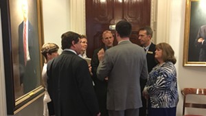 A group of Democratic lawmakers who supported Gov. Phil Scott’s proposal confer outside his office Wednesday afternoon.