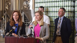 Amanda O'Brien (left) and Laura Pierce talk Monday at Fiddlehead Brewing about helping young adults find work in Vermont as Gov. Phil Scott (right) and Paul Dame  look on.