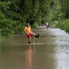 A man walking through flood waters at Burlington's Intervale on Tuesday